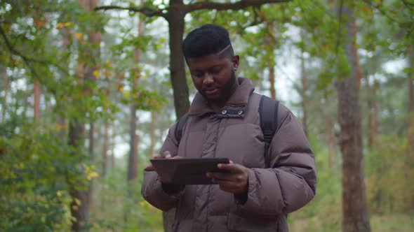 African Hiker Man Using Gps App on Digital Tablet
