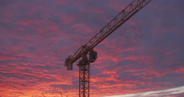 Golden bluish clouds over construction site glow in the light of a sunset