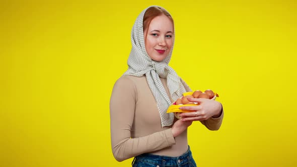 Beautiful Freckled Redhead Woman in Kerchief Holding Egg Tray Looking at Camera and Smiling