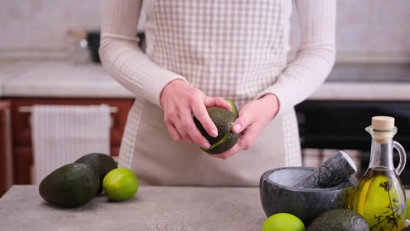 Close Up of Woman Hands Halving Avocado at the Domestic Kitchen