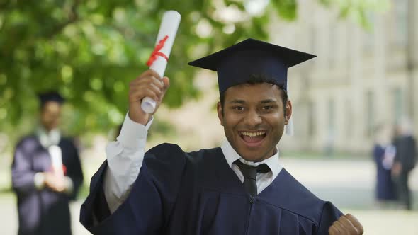 Cheerful Male Graduate Showing Certificate for Camera and Smiling, Success