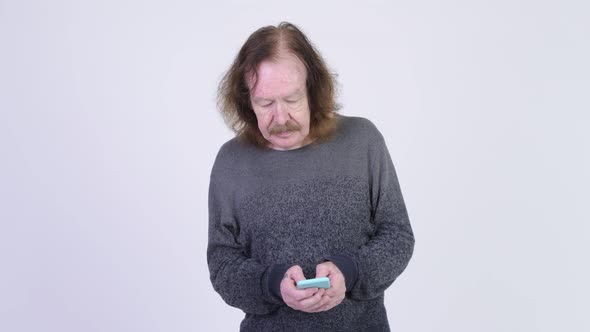 Happy Senior Man with Mustache Using Phone and Thinking