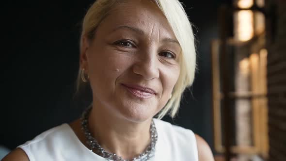 Beautiful Middle Aged Woman With Dark Eyes Smiling at Camera