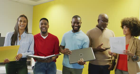 Portrait of diverse male and female business colleagues smiling in office