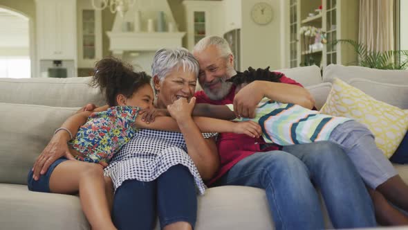 Grandparents embracing their grandchildren at home