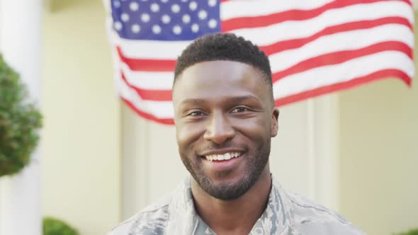 Portrait of african american male soldier smiling over american flag