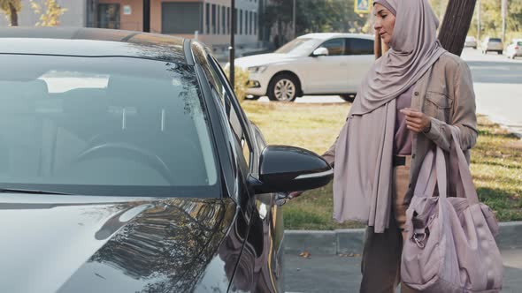 Muslim Woman with Gym Bag Getting in Car