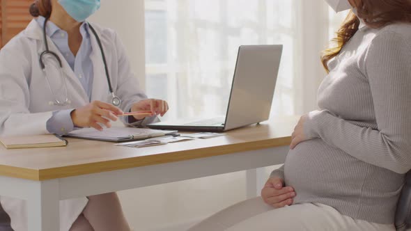 Professional Asian doctor woman consulting pregnant patient