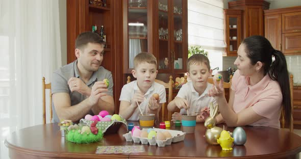 Happy Family Painting Easter Eggs in Kitchen