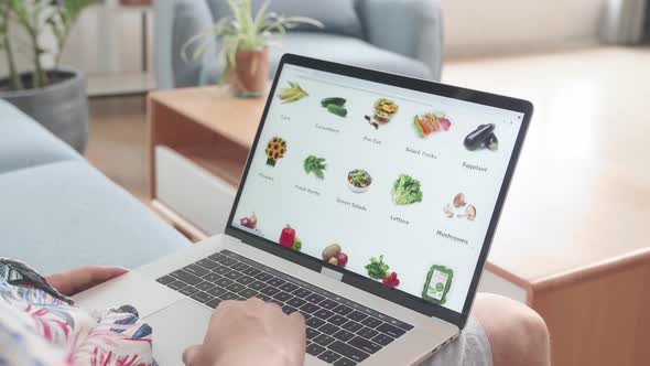 Man Using Laptop Computer Buys In Internet Shop. Male Selects Vegetables In Grocery Online Store