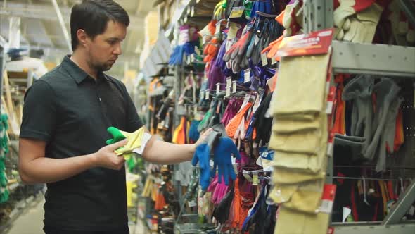 Male Customer in the Hardware Store Choosing Garden Gloves