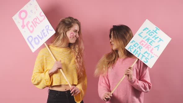 Two Slim Feminists Isolated Over Pink Background