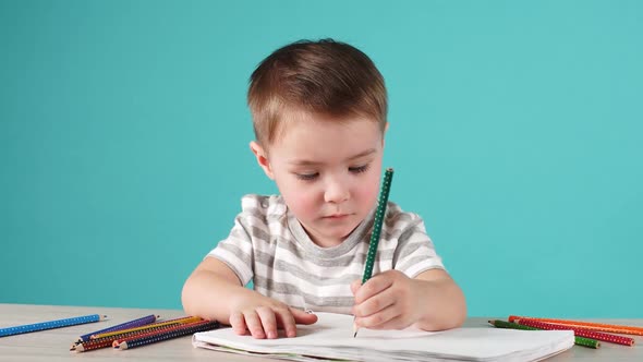 Happy Child Drawing with Pencils in Album, Isolated on Blue