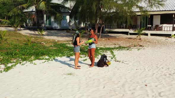 Beautiful women enjoying life on relaxing bay beach wildlife by blue water and white sandy backgroun