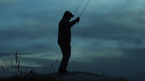 Athlete Outdoors In The Dark. Silhouette Of An Athlete Jumping Rope