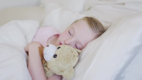 Side view of Caucasian girl sleeping on bed