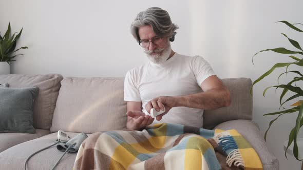 Old Man Is Taking in Pills Sitting at Home