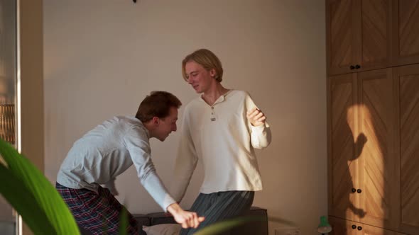 Happy gay couple dancing on the bed