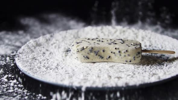 White Ice Cream Sundae Falls Into White Powder In A Plate.