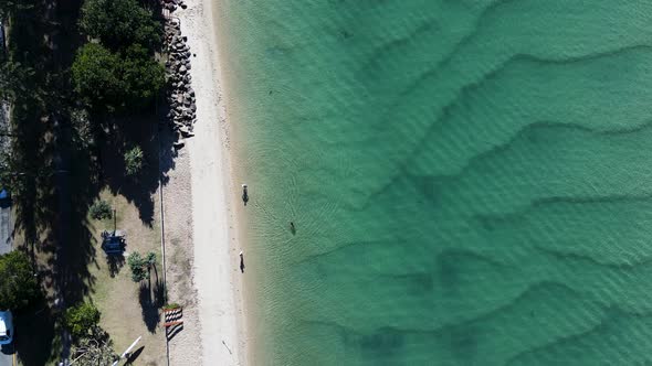 Scenic high view over a crystal clear creek at a popular family holiday park and beach area. Moving