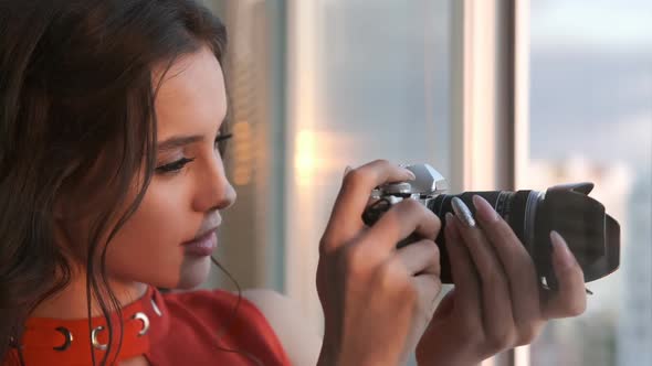 Young Woman with a Camera By the Window.