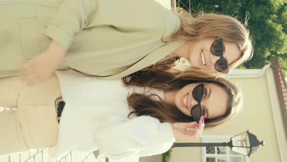 Two young beautiful women posing outdoors 