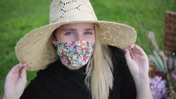 Fashionable girl wearing face mask flirting with camera at the park