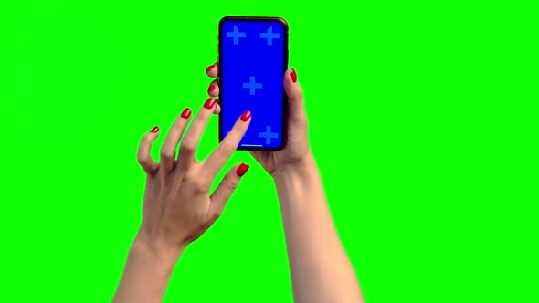 The Girl Holds a Smartphone with a Blue Screen, Runs Her Finger Along the Screen and Makes a Double