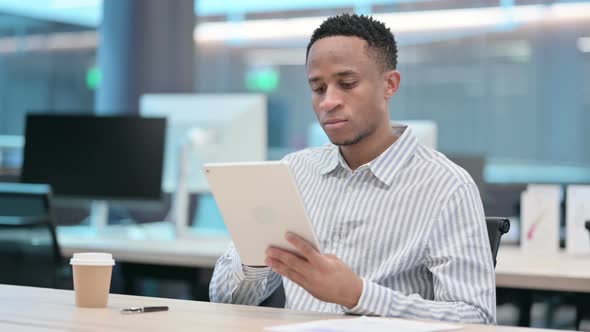 Attractive African Businessman Using Tablet in Office