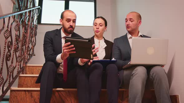 Coworkers Discussing Plans Sitting on Stairscase