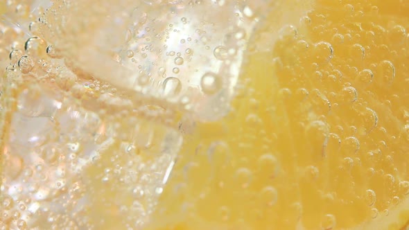 Macro Closeup Shot of Cold Refreshing Soda Tonic Fizzy Water Drink with Bubbles Interacting with Ice