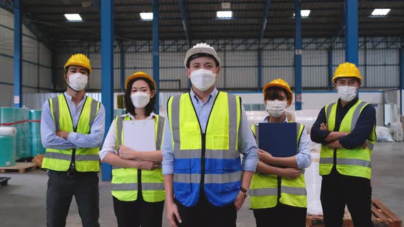 Group of warehouse or factory workers with face mask stand as line formation in workplace area