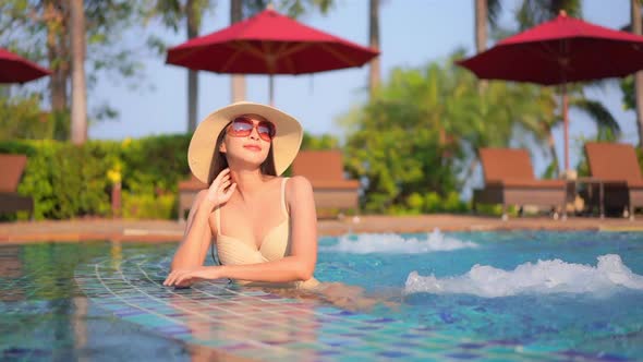 Young asian woman enjoy around outdoor swimming pool for leisure