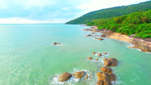 Aerial Top views over beaches, ocean waves crashing on rocks and sand