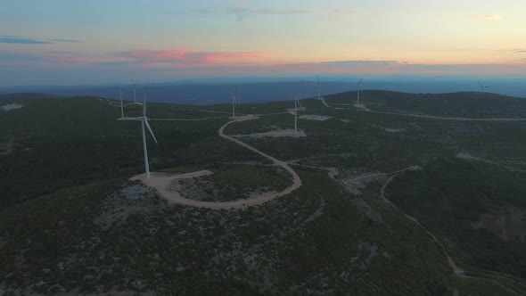 Aerial view of nine windmills for the production of electric energy, at sunset