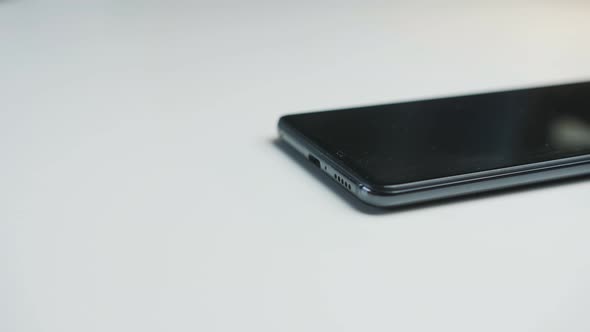 Close Up of a Man's Hands Connecting a Power Cable to a Smartphone to Charge the Battery