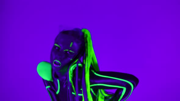 Portrait of Confident Woman with Fluorescent Makeup in Bright Costume Dancing Robotic Dance Looking