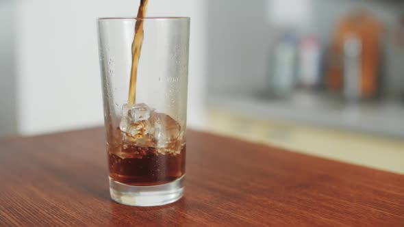 Cola is Poured into Transparent Glass The camera Moves Around the Table in the kitchen