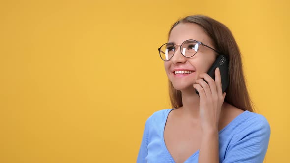 Closeup Happy Woman Talking Smartphone with Positive Emotion Isolated on Orange Studio Background