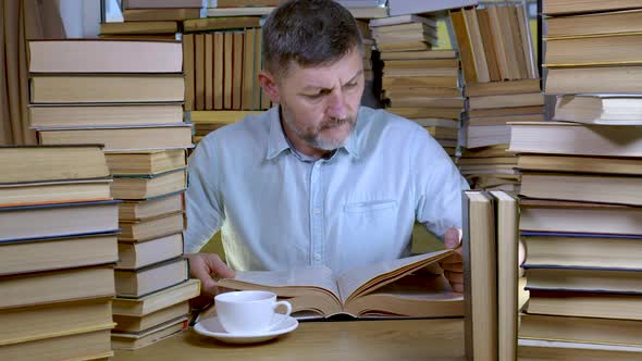 A Bearded Man Reads a Book in the Library