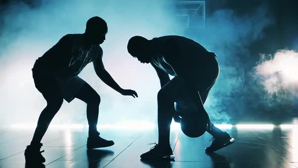 Africanamerican Athletes are Competing for a Basketball in the Dark