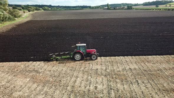 Aerial footage over tractor ploughing field