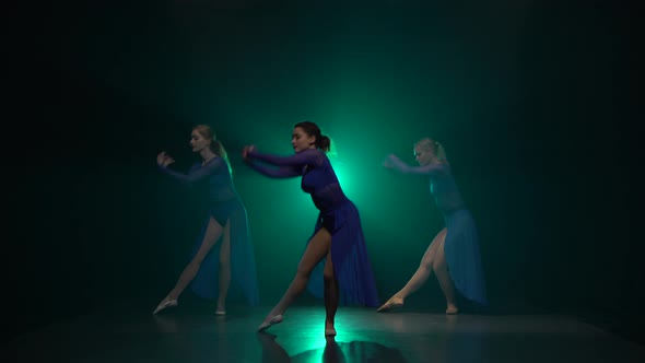 Professional Ballerinas Are Dancing Against Green Spotlight of Studio