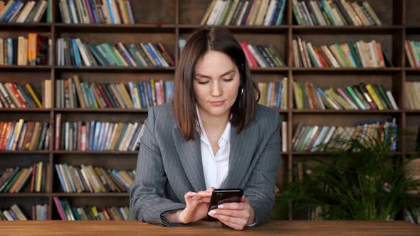 Stylish Businesswoman in Jacket Types on Black Smartphone