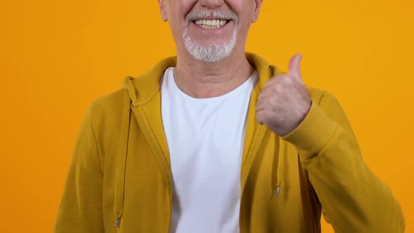 Joyful Bearded Male Showing Thumbs Up, Approval Gesture, Recommendation Sign