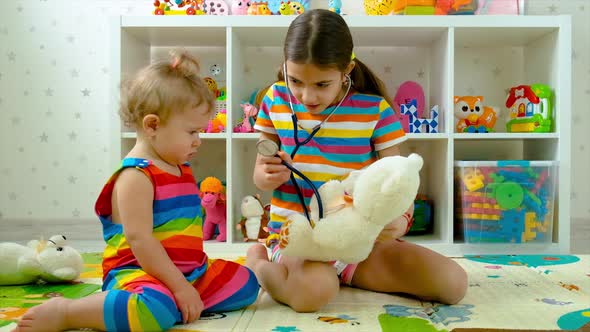 Children Treat a Teddy Bear Toy