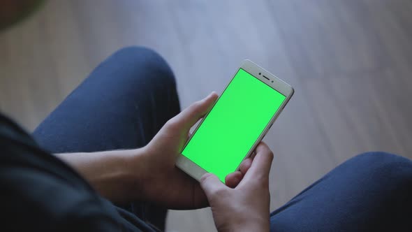 Closeup of Male Hands Holding Smart Phone with Green Screen Prekeyed for Effects. Useful Mobile