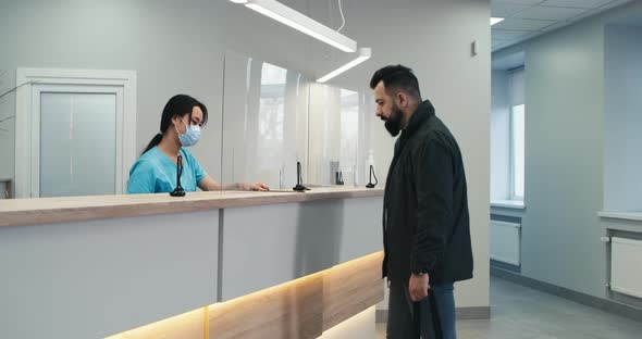 Male Patient Signing Contract on Clinic Reception