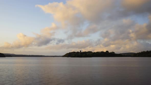 Time lapse of a castle ruin on lake horizon during sunset evening in Ireland.