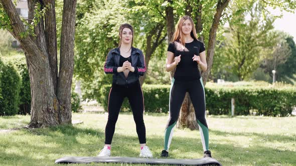 Two Pretty Young Women Are Training in the Park